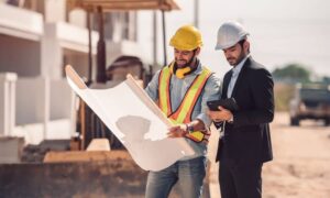 Civil engineer and contractor reviewing blueprints at a construction site in Colorado Springs