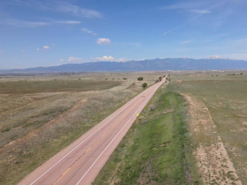 Aerial view of open land and highway near Schriever Space Force Base showing area involved in the Karman Line Annexation boundary survey