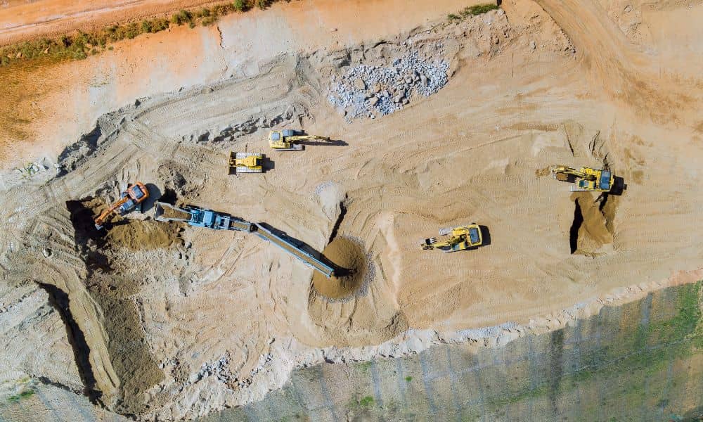 Aerial view of an active land development site with excavators working on grading