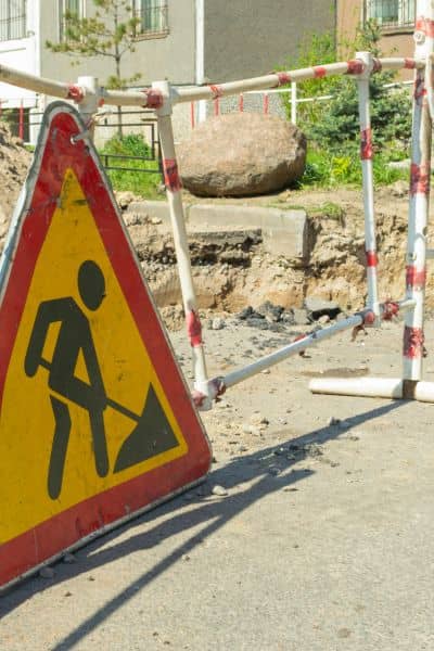 Roadway construction sign stormwater project - ALTA SURVEY Colorado Road work sign and safety barriers at construction site preparing drainage and stormwater upgrades