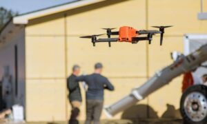 Drone land surveying in progress above an active construction site with crews working on ground layout