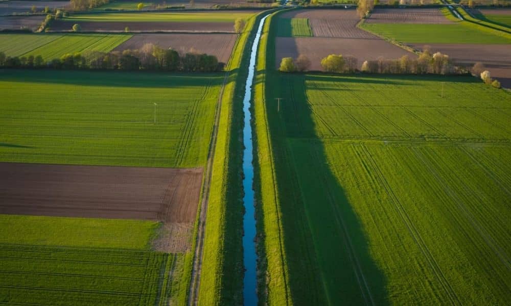 Aerial view of an irrigation ditch crossing agricultural land documented by a due diligence survey